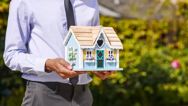 person holding a small house